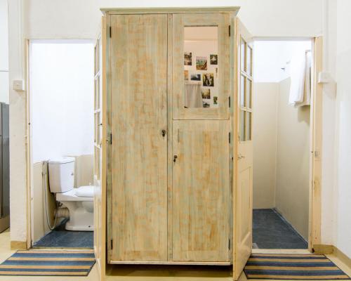 a wooden door in a bathroom with a toilet at BunkyDew in Galle