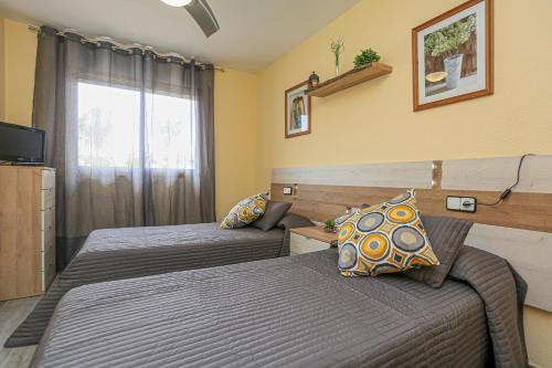 um quarto de hotel com duas camas e uma janela em Cambrils Park B 2 B ONLY FAMILIES em Cambrils