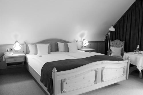 a bedroom with a large white bed and two tables at Landhotel Hubertus in Unterelsbach