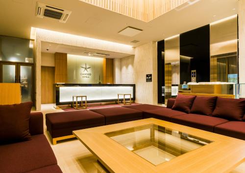 sala de estar con sofá y mesa en Candeo Hotels Fukuoka Tenjin, en Fukuoka