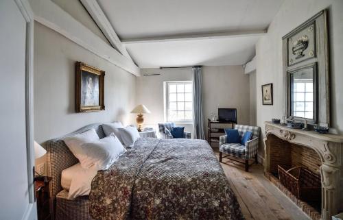 a bedroom with a large bed and a fireplace at Château du Tertre in Arsac
