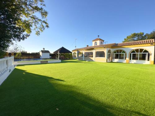 a large green yard with a large house at VILLA MACARENA in Espera