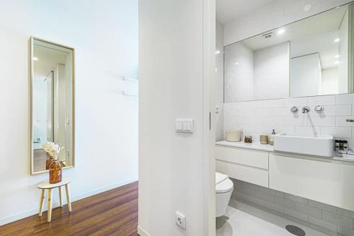 Baño blanco con aseo y lavamanos en Bombarda Apartments VII by Innkeeper, en Oporto