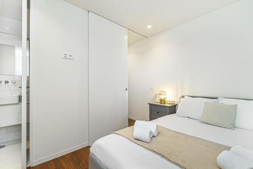 1 dormitorio blanco con 1 cama grande y paredes blancas en Bombarda Apartments VII by Innkeeper, en Oporto