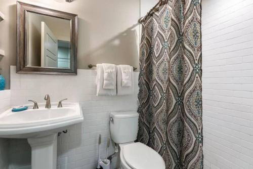 uma casa de banho com um lavatório, um WC e uma cortina de chuveiro. em Urban Living in the Heart of New Orleans em Nova Orleans