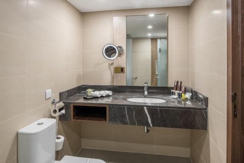 a bathroom with a sink and a toilet at Makarem Ajyad Makkah Hotel in Makkah