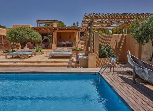 a backyard with a swimming pool and a wooden deck at Kasbah 3 in Cala Vadella