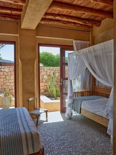 a bedroom with a canopy bed and a window at Kasbah 3 in Cala Vadella