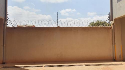 an open door with a fence with a view at Pine Residency w Secure Parking, Wifi, Netflix & Rooftop Views in Kikuyu