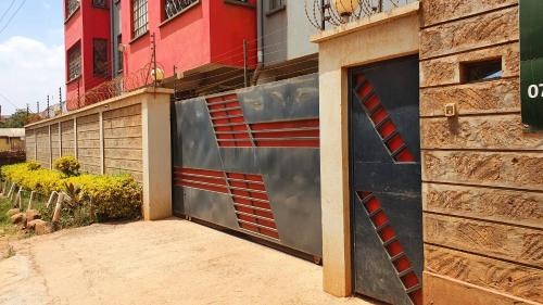 a garage door of a building with a fire ladder at Pine Residency w Secure Parking, Wifi, Netflix & Rooftop Views in Kikuyu