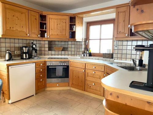 a kitchen with wooden cabinets and a stove top oven at Landhaus Obermaiselstein "THE VIEW" in Obermaiselstein