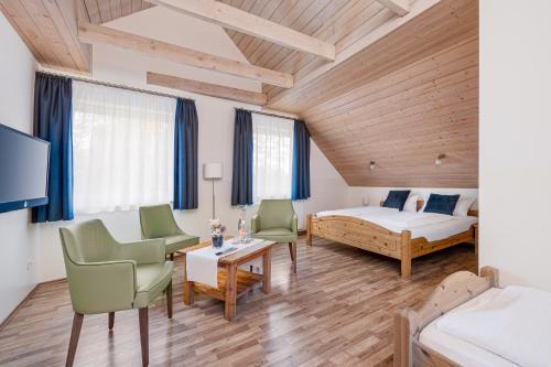 a bedroom with a bed and two chairs and a table at Haus Biederstaedt in Ottersberg