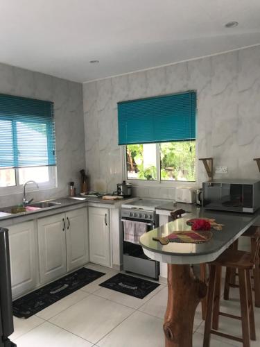 a kitchen with white cabinets and a table in it at FOND B'OFFAY LODGE in Victoria