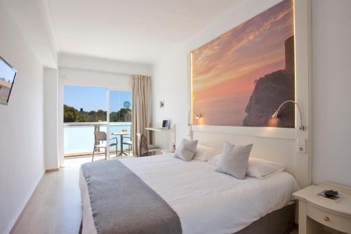 a hotel room with a large bed and a balcony at Hotel Ankaa - Adults Only over 14 in Porto Cristo