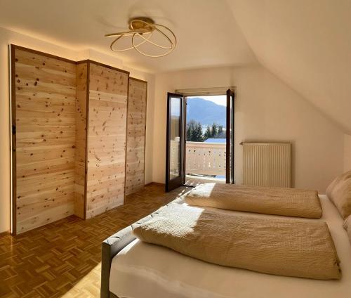 ein Schlafzimmer mit einem Bett und einem großen Fenster in der Unterkunft Haus Christoph in Winklern