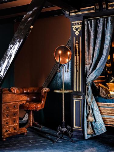 a room with a chair and a table and a curtain at Private and chique Salon de Franz in Amsterdam