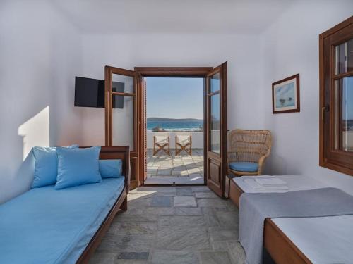 a bedroom with a bed and a view of the ocean at Golden Beach Villa Paros in Chrissi Akti