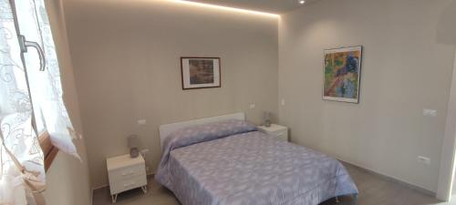 um pequeno quarto com uma cama e duas fotografias na parede em Valdisieve Guest House Appartamento 20 minuti da Firenze em Pontassieve