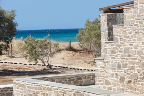 a stone building with a view of the beach at Golden Beach Villa Paros in Chrissi Akti