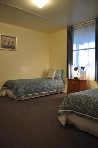 a bedroom with two beds and a window at GreenGate Cottages in Strahan