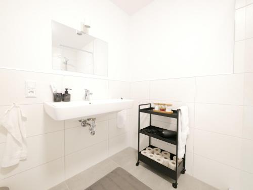 uma casa de banho branca com um lavatório e um espelho em 75 m2, zentral, Küche, Balkon, Parkplatz em Osnabrück