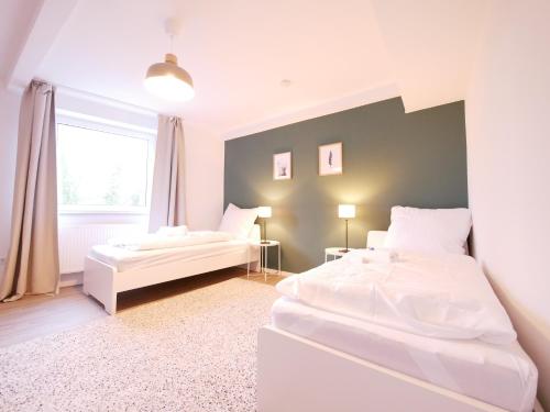 2 weiße Betten in einem Zimmer mit Fenster in der Unterkunft 75 m2, zentral, Küche, Balkon, Parkplatz in Osnabrück