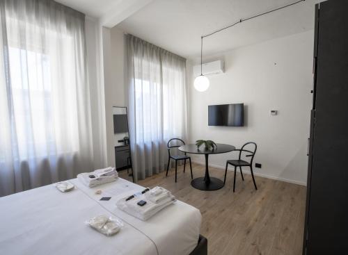 a room with a bed and a table with chairs at San Carlo Suite Torino in Turin