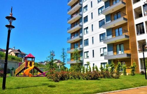 a playground in a park next to a building at YALINCAK TERAS 1 SİTESİ in Cimenli