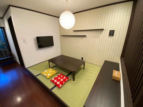 ein Wohnzimmer mit einem Tisch und 2 Kissen in der Unterkunft Yuzenkyo in Kyoto