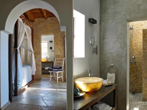 a bathroom with a large bowl sink and a bedroom at Kasbah 2 in Sant Josep de Sa Talaia