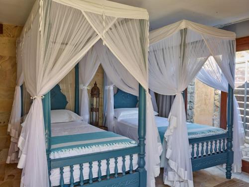 2 camas en un dormitorio con cortinas blancas en Kasbah 2, en Sant Josep de sa Talaia