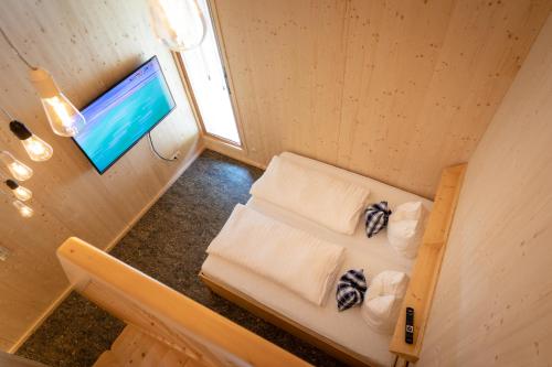 einen Blick über ein Zimmer mit einem Bett und einem TV in der Unterkunft Prefelnig Glamping Lodge Ossiacher See in Ossiach