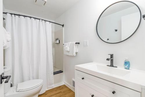 a white bathroom with a sink and a mirror at Tidal House 3 in Ocean Shores