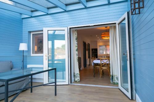 uma porta de vidro deslizante numa casa azul com uma mesa em The Kinsale 4 Center em Kinsale