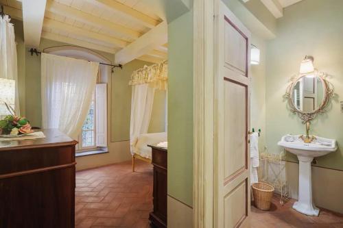 ein Bad mit einem Waschbecken und einem Spiegel in der Unterkunft Villa Melangola in Camaiore