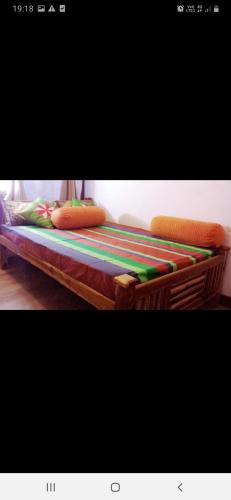 a bed with colorful blankets and pillows on it at Beni Beach Resort Batticaloa, Sri Lanka in Kallady