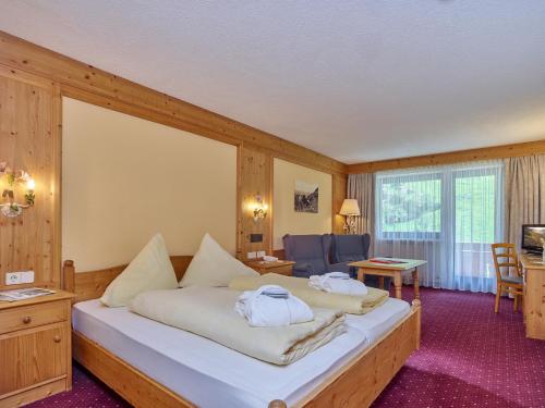 sypialnia z dużym białym łóżkiem w pokoju w obiekcie Hotel Erhart Sölden inklusive Summer Card w Solden