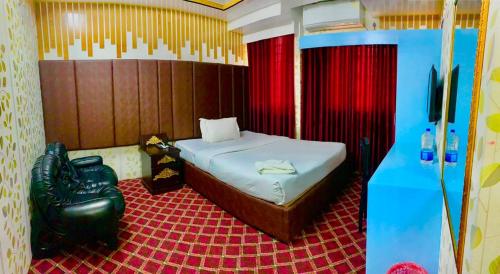 a bedroom with a bed and a tv in it at Hotel Heaven Inn in Dhaka