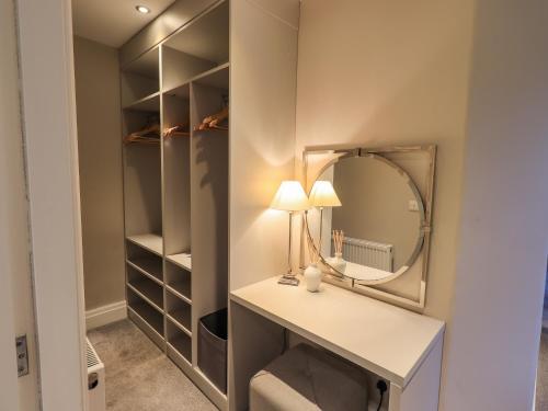 a dressing room with a vanity and a mirror at Honeywood House in Grasmere