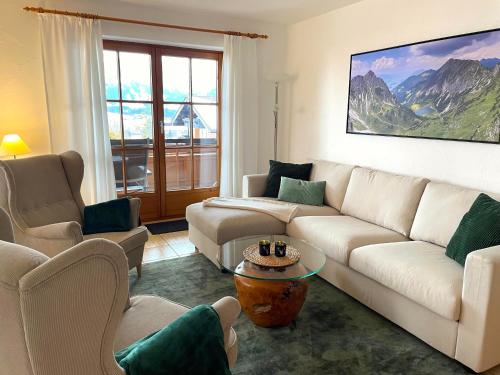a living room with a couch and chairs and a table at Landhaus Obermaiselstein "THE VIEW" in Obermaiselstein