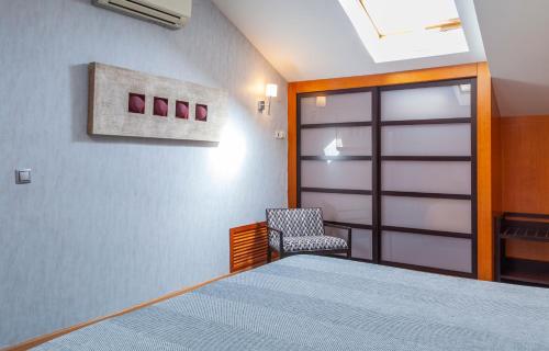 a bedroom with a bed and a chair and a door at Hotel Macià Alfaros in Córdoba