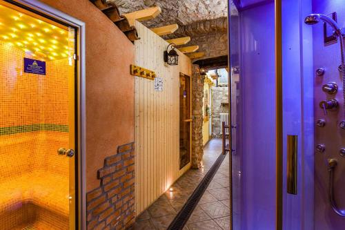 ティニャーレにあるHotel Castelloの紫色のドアとウォークインシャワー付きのバスルーム