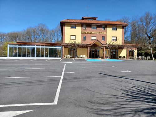 um parque de estacionamento vazio em frente a um edifício em Hotel Restaurante Val em Antas de Ulla