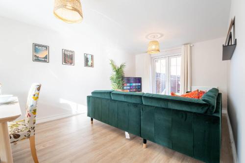 a green couch in a living room with a window at Brookfield in Horley