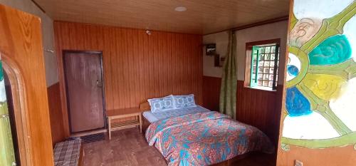 Daragaon Retreat (Gurung Homestay) في بيلينغ: غرفة نوم مع سرير ونافذة زجاجية ملطخة