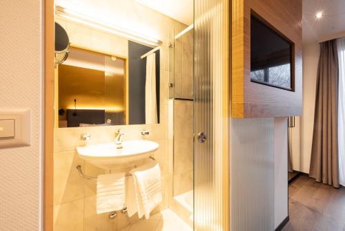 a bathroom with a sink and a mirror at Engimatt City & Garden Hotel in Zürich