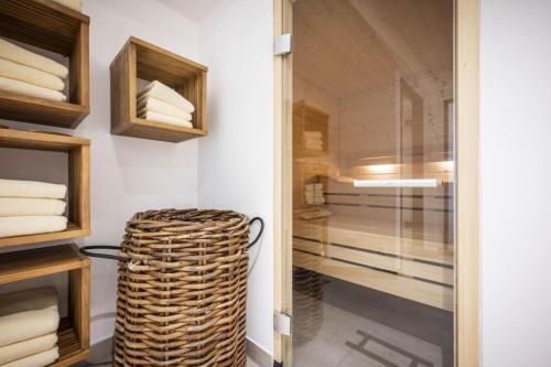 a walk in closet with a wicker stool next to a glass door at Ferienwohnung 206 Juist Strandburg für 5 Personen mit Schwimmbad und Sauna in Juist