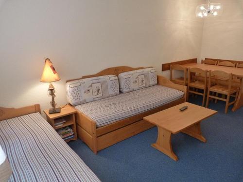 Cette chambre comprend un lit et une table. dans l'établissement Joli 2 pièces cabine rénové, exposition sud, skis aux pieds, Résidence Boedette A, Les Menuires - FR-1-178-182, aux Menuires