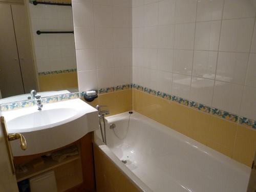une salle de bain avec une baignoire blanche et un lavabo dans l'établissement Joli 2 pièces cabine rénové, exposition sud, skis aux pieds, Résidence Boedette A, Les Menuires - FR-1-178-182, aux Menuires