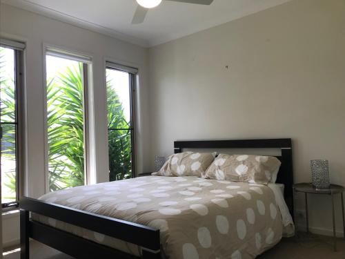 a bedroom with a bed and two windows at Privileged location close to all in Mount Duneed